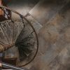 Cast Rust Dark Rusty Antiqued Metal Effect Porcelain Tile Showing Checker Plate Surface Below Metal Spiral Staircase