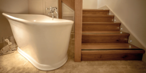 Wooden Staircase leading into bathroom with tiled floor