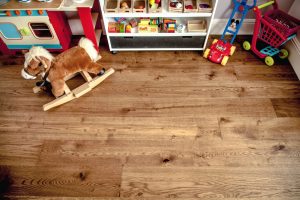 Beautiful wood flooring with childrens toys along a wall.