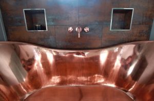 Chrome bath with tiled with soft reddish hues