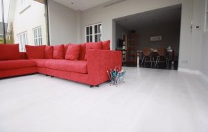 Hard Wood Flooring, Red Sofa with magazine rack next to it