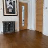 Barnston Mixed Width Traditional Oil Oak Flooring installed in Living Room with Cast Iron Radiator